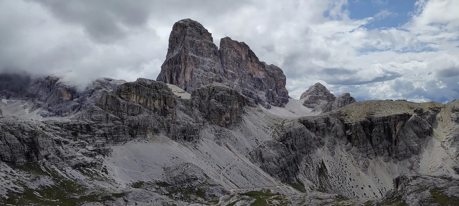 Rugged Dolomite peaks and scree slopes under heavy clouds